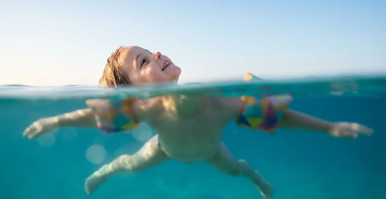 Enfant démontrant la position de l'étoile de mer pour flotter en sécurité