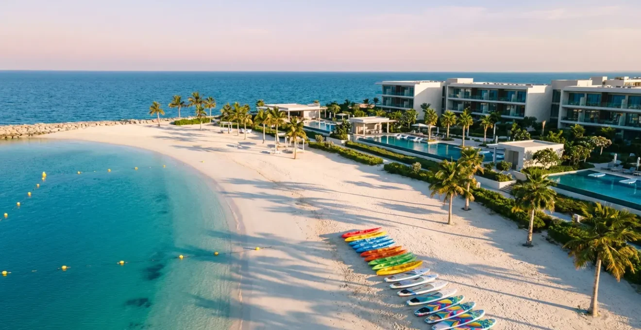 Vue aérienne d'un complexe hôtelier en bord de mer avec zone dédiée aux sports nautiques et équipements colorés