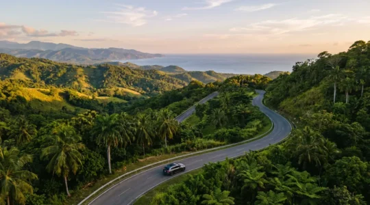 Route sinueuse traversant les montagnes tropicales de la République Dominicaine avec vue sur l'océan